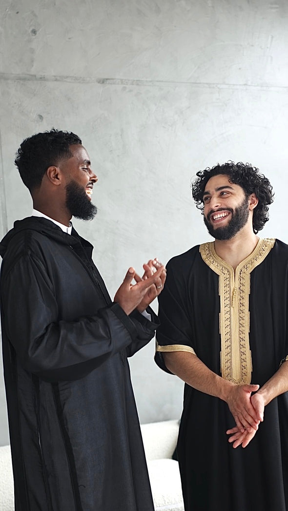 Two muslim men wearing moroccan and emirati thobe smiling