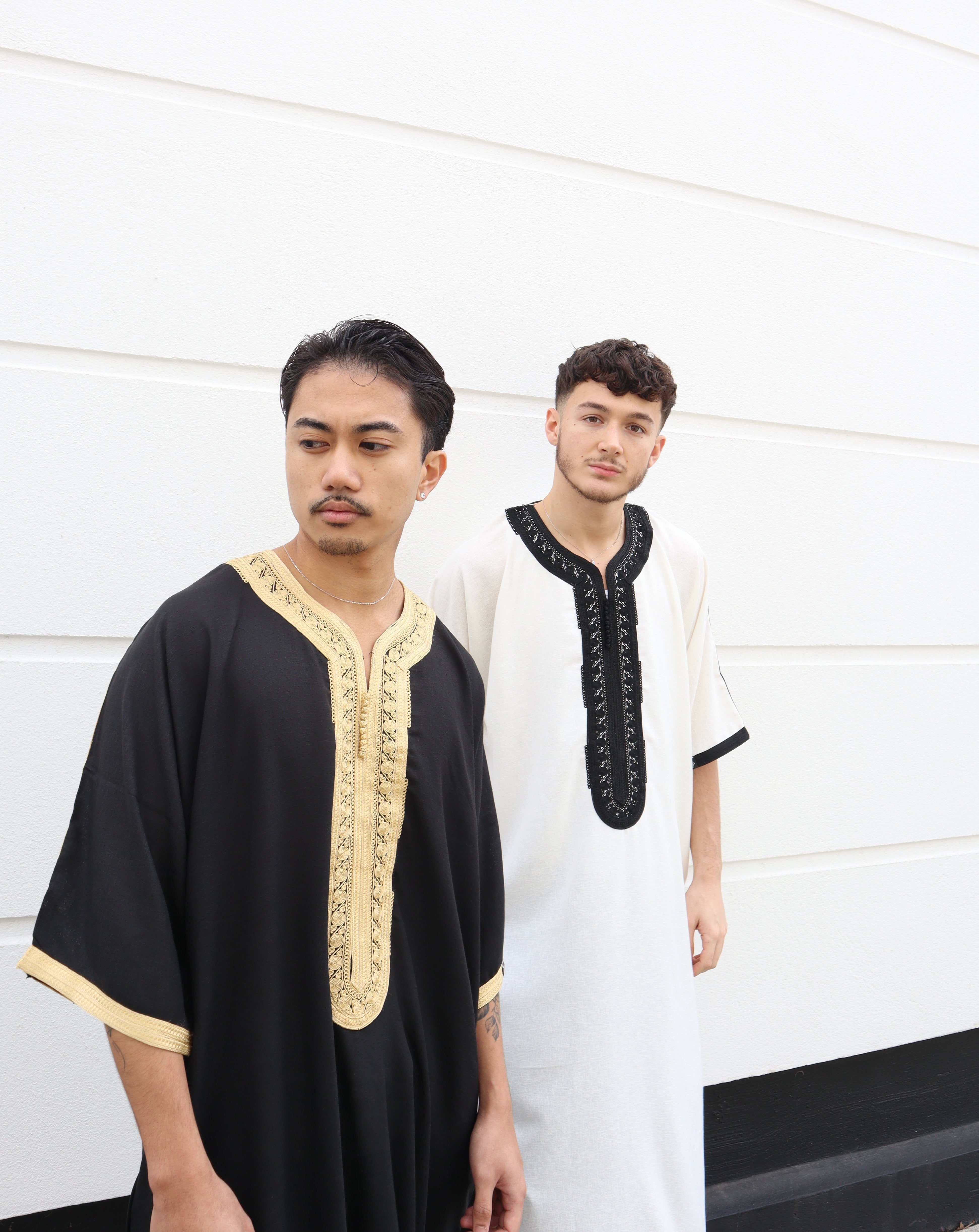 two muslim men wearing thobes