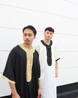 two muslim men wearing thobes